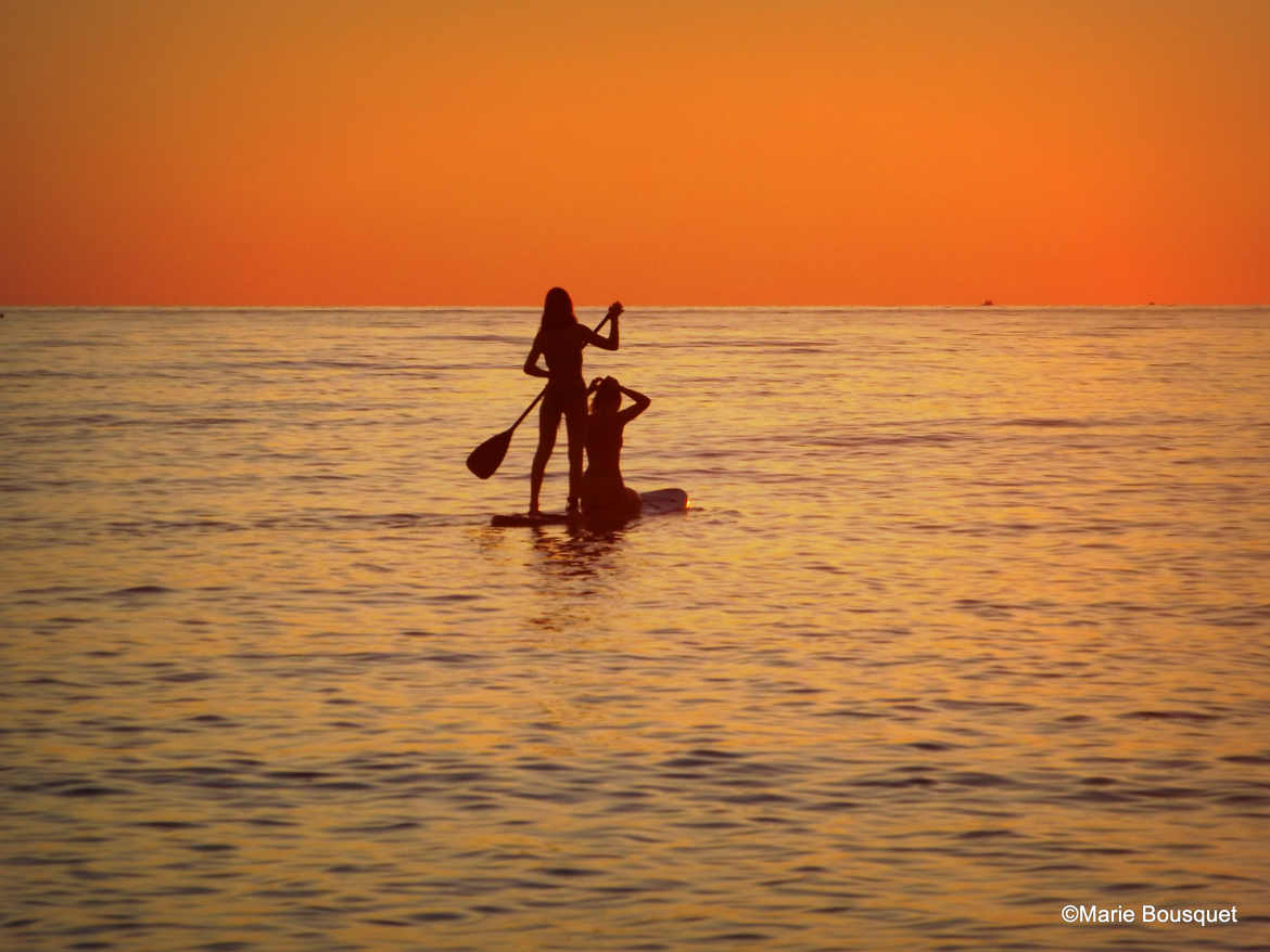 Silhouettes sur la mer au soleil levant