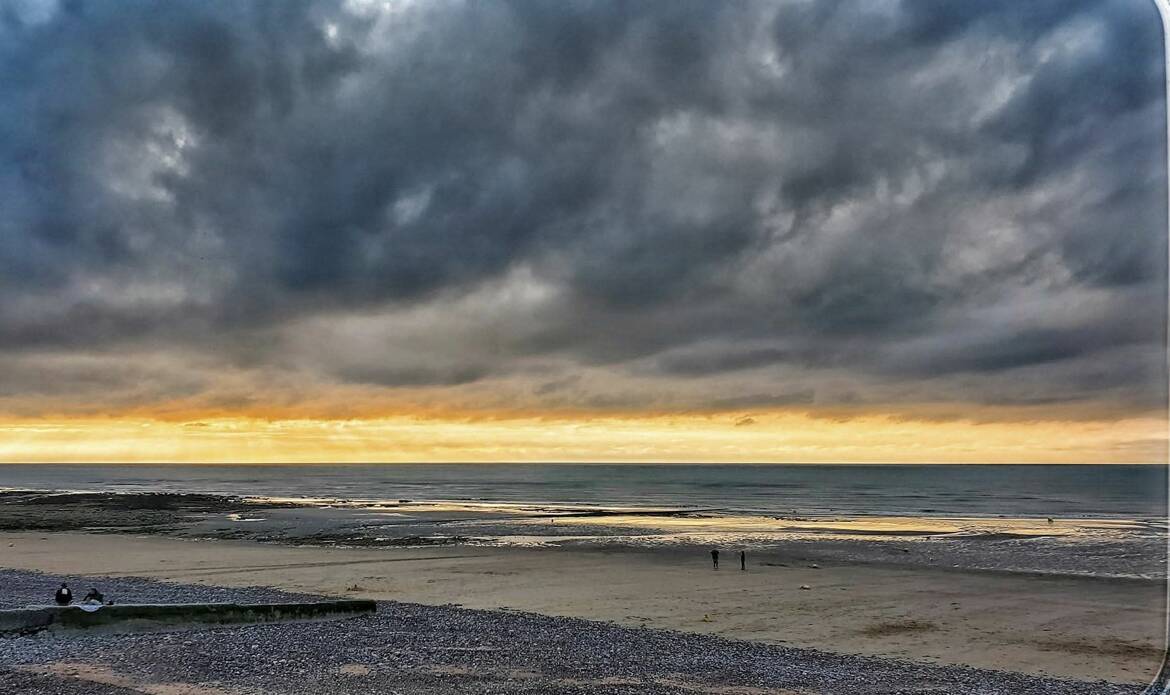 Sous un ciel d’orage, la mer s’embrase d'or, l’horizon brûle au seuil de la nuit.