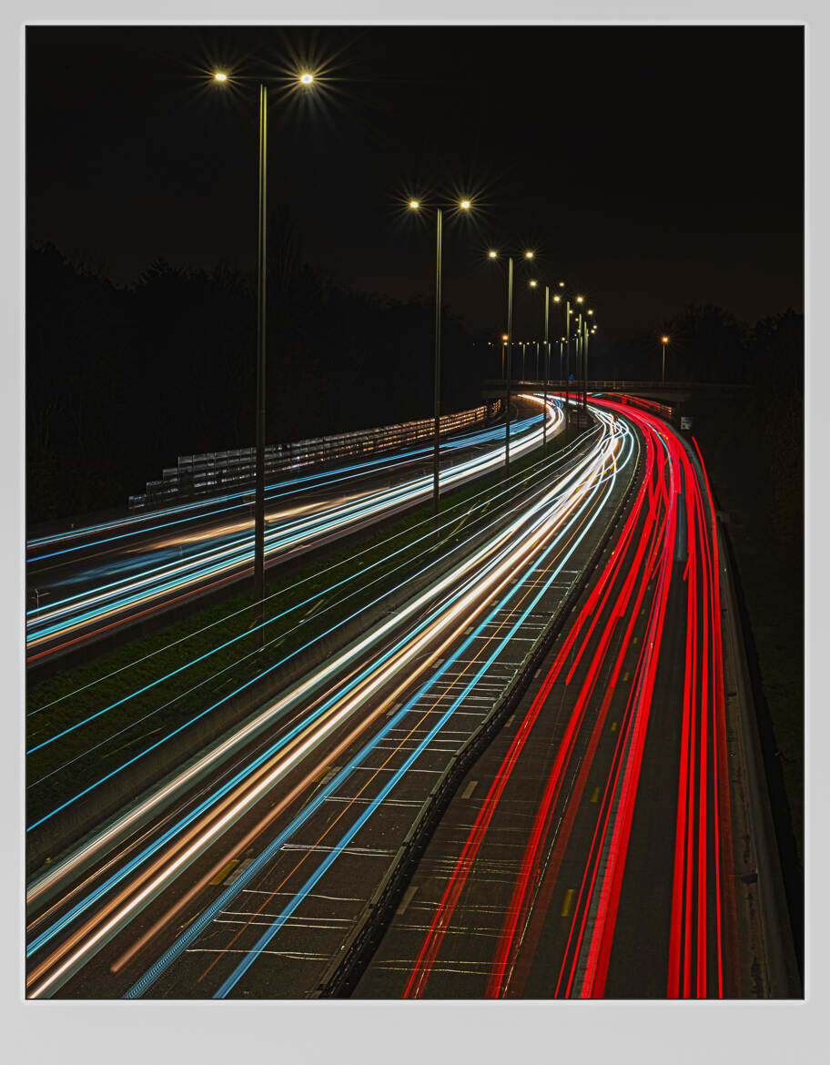 Une autoroute la nuit prise avec une technique de longue exposition.