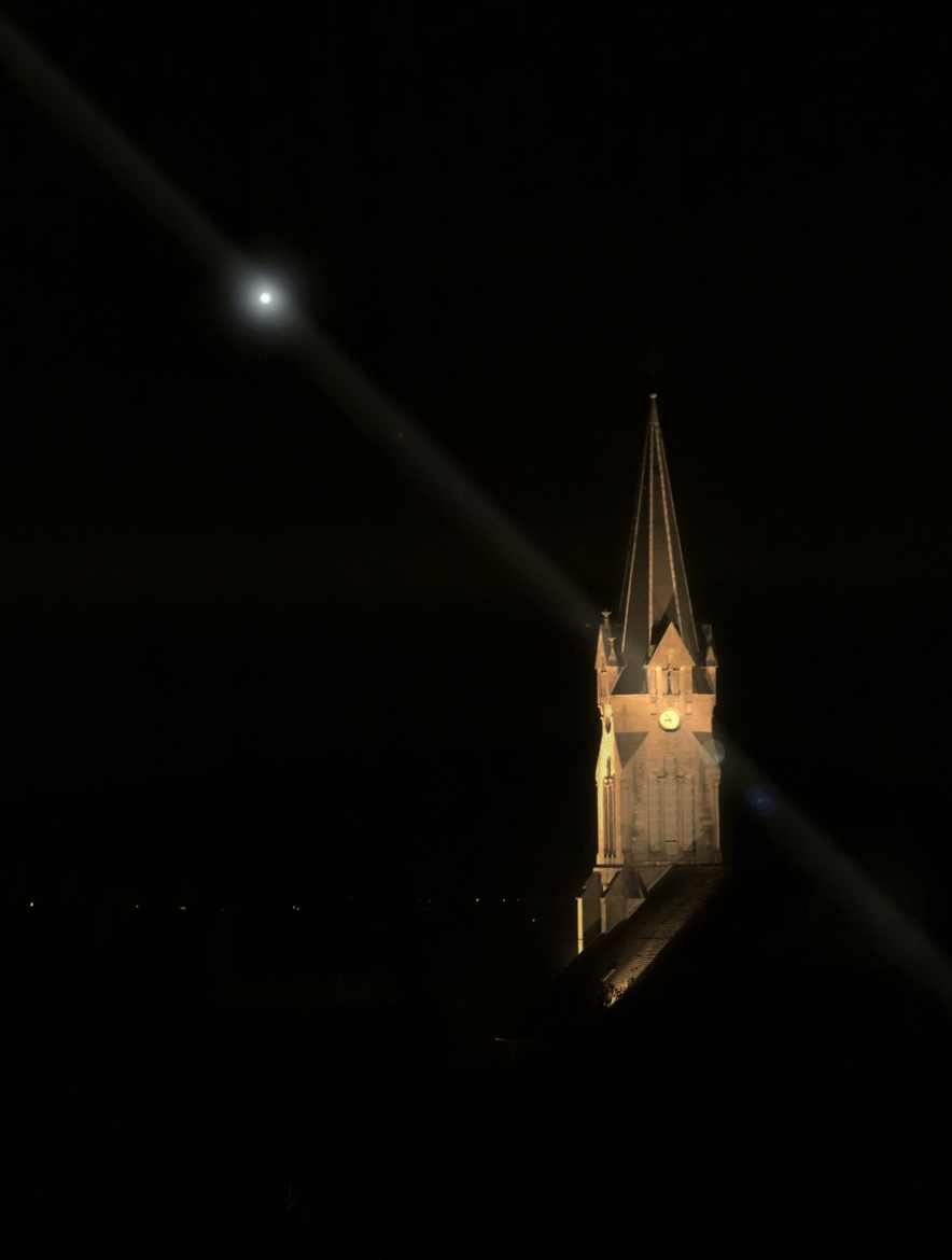 Dans la nuit sombre seul le clocher illuminé pour préparer Noël