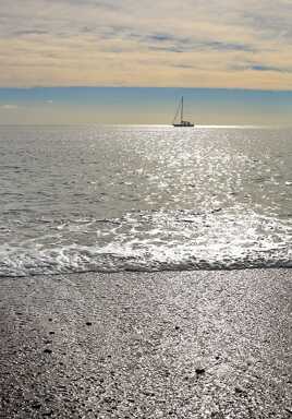 Un voilier passe dans la brise du matin.