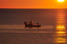 Petit pêcheur remontant ses filets à l'aube